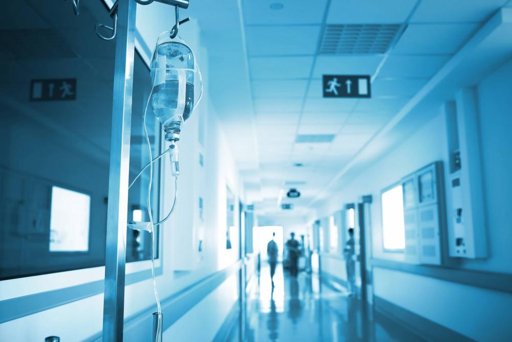 Image of a hospital hallway with an IV bag